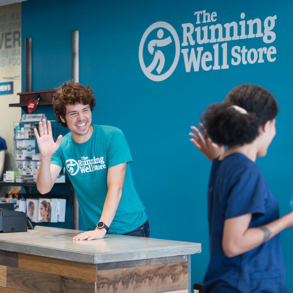 the running well store employee waving goodbye to a customer after purchasing running shoes in kansas city
