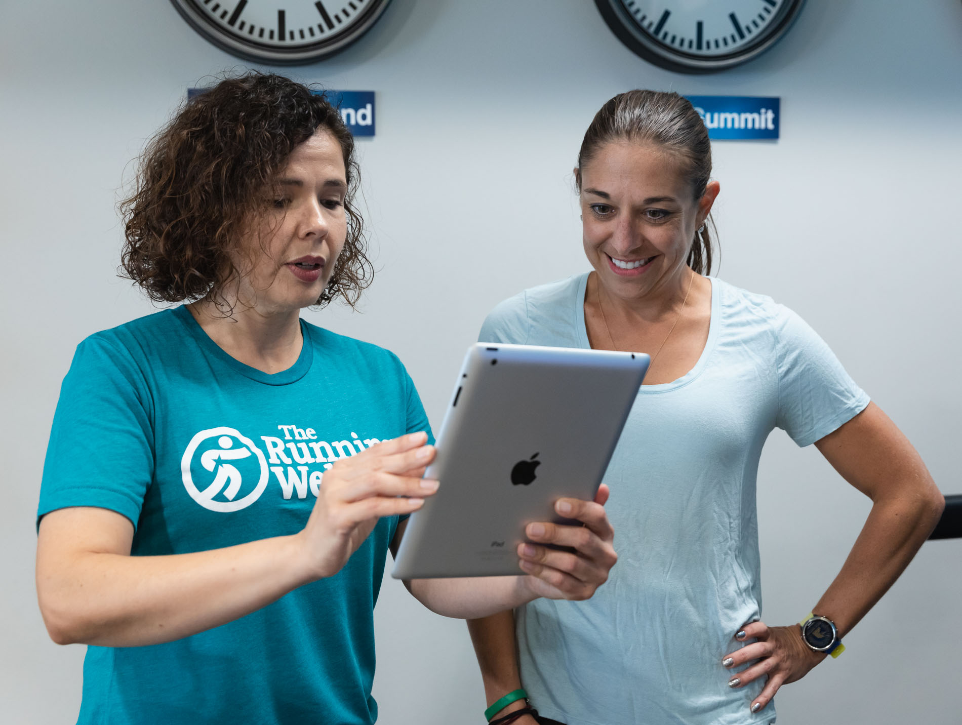 two women reading ipad to discover proper stride analysis and running shoe fit