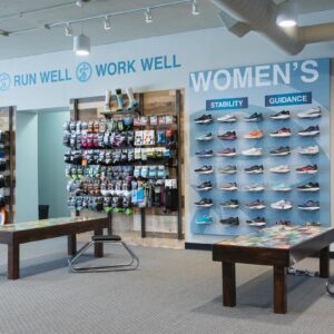image of the running well store, including try-on areas and a wall of running shoes, socks, and more running products available in kansas city