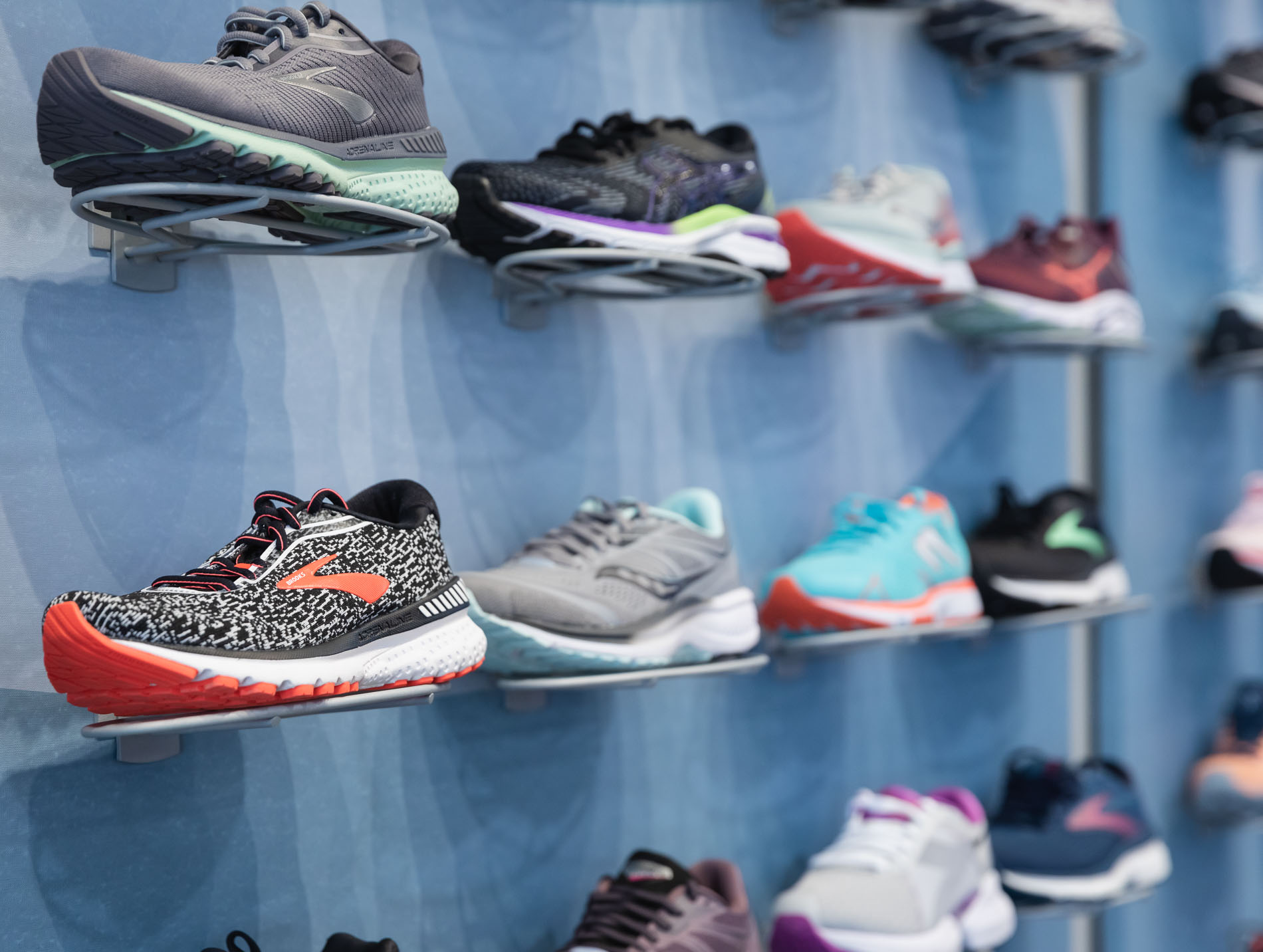 wall of running shoes available at the running well store in kansas city