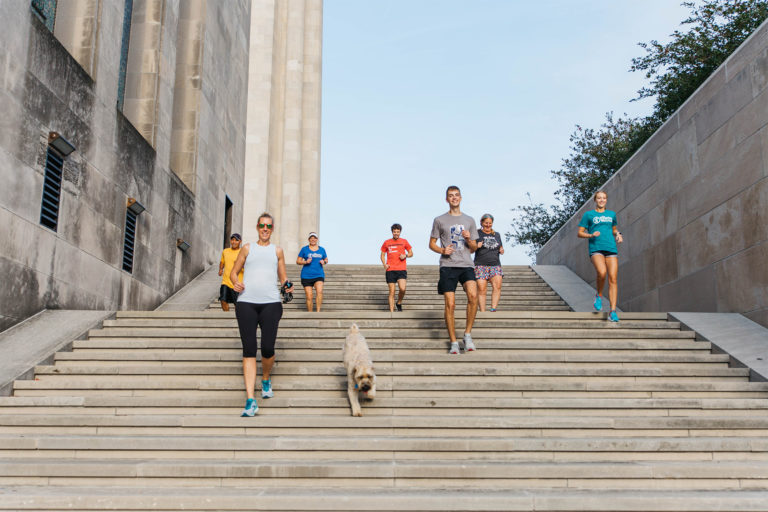 group of friends jogging at the liberty memorial in kansas city